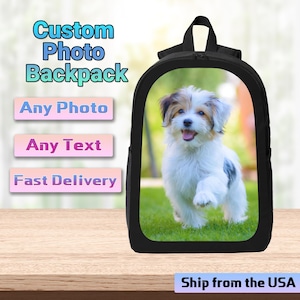 May include: Black backpack with a photo of a small, white and brown dog on green grass. The backpack has the text "Custom Photo Backpack", "Any Photo", "Any Text", and "Fast Delivery".