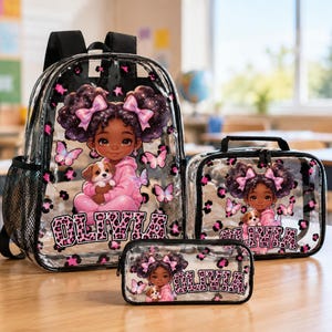 May include: A clear backpack, lunch bag, and pencil case set featuring a cartoon illustration of a girl with dark hair in pigtails holding a puppy, surrounded by pink butterflies and leopard print accents, with the name OLIVIA printed in block letters.