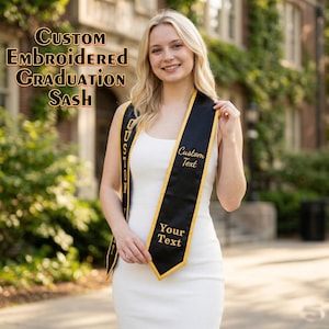 May include: A black and gold custom embroidered graduation sash. The sash has gold trim and text that reads "Custom Text" and "Your Text". The words "Custom Embroidered Graduation Sash" are printed at the top of the image.