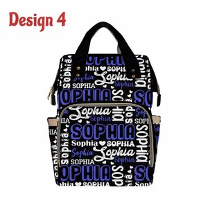 K&ouml;nnte beinhalten: Schwarze Wickeltasche mit einem blauen und wei&szlig;en Muster, auf dem der Name "Sophia" wiederholt vorkommt. Die Tasche hat eine Rei&szlig;verschlusstasche auf der Vorderseite und einen goldenen Rei&szlig;verschluss.