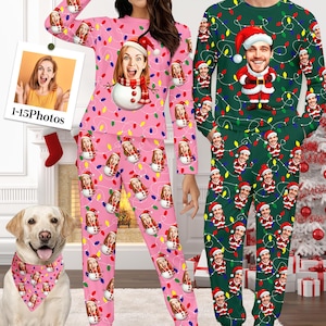 May include: Pink Christmas pajamas with a repeating pattern of a woman's face, a snowman, and string lights. The matching top and pants set is worn by a person. A dog wears a matching bandana. A second person wears green Christmas pajamas.