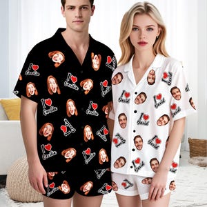 May include: Matching pajama sets, one black and one white, each featuring a repeating pattern of faces, hearts, and names. The black set says "I Cecilia" and the white set says "I David". Both sets include a button-down shirt and shorts.