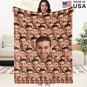 May include: A brown fleece blanket with a pattern of many faces. The faces are of different people, including adults and children. The blanket is made in the USA.