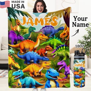 May include: A soft blanket and a matching water bottle featuring a colourful jungle scene with various dinosaurs in shades of orange, blue, green, and purple. The name JAMES is printed in large orange letters on both items.