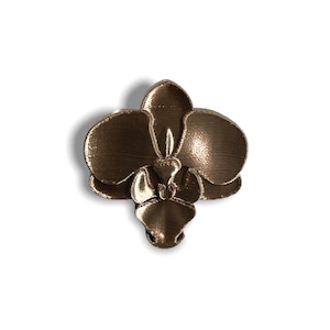 May include: A bronze-colored orchid flower brooch with a detailed, textured finish.