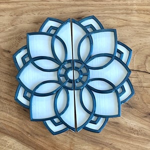 May include: A pair of white and blue 3D printed door handles shaped like a mandala. The handles are separated into two halves.