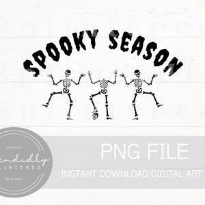 以下が含まれることがあります： 3体の黒い骸骨が「Spooky Season」という文字の下で踊っています。骸骨は白い背景に描かれています。