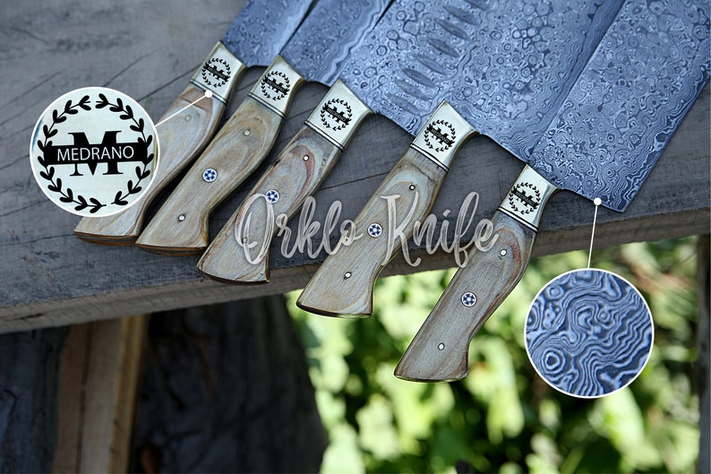 May include: A collection of knives with patterned steel blades and light wood handles. Each knife has a decorative metal bolster and a small, circular inlay. The blades have a unique, swirling pattern. The text "Orklo Knife" is visible.