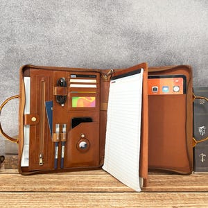 May include: A set of three ceramic vases in varying heights and shapes. The vases feature a matte white finish and a textured, ridged design. They are arranged on a neutral surface, showcasing their minimalist aesthetic.