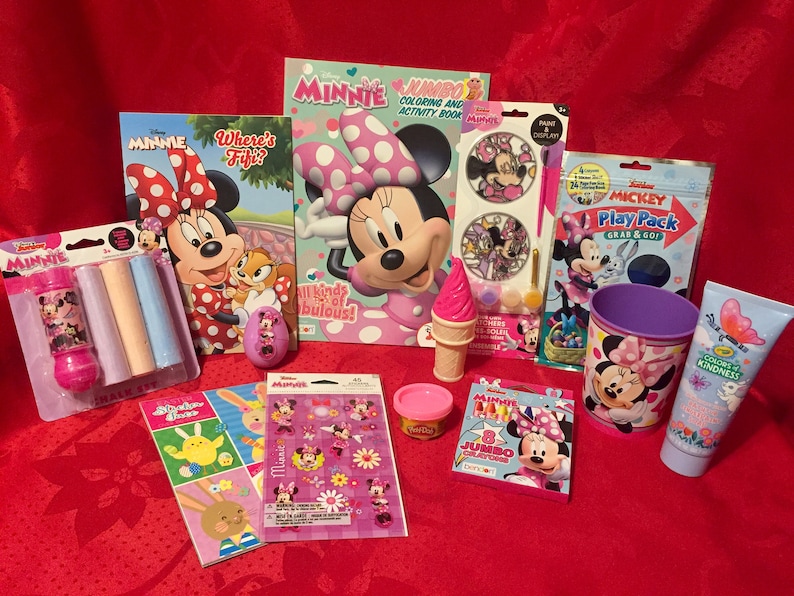 Puede incluir: Una colecci&oacute;n de juguetes y libros para ni&ntilde;os con el tema de Minnie Mouse. Los art&iacute;culos incluyen un libro para colorear, un libro de pegatinas, un paquete de juego, una taza, un producto de ba&ntilde;o, crayones, tiza y una varita de burbujas.