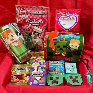 May include: A collection of Minecraft-themed items, including a green and brown tin, candy, a coloring book, and pixelated sunglasses. The items are arranged on a red surface, creating a festive gift basket.