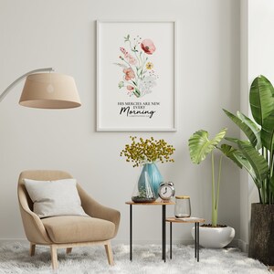 May include: A watercolour print featuring a floral design and the text "His mercies are new every morning. Lamentations 3:23". The print is framed and hanging on a white wall in a living room setting.