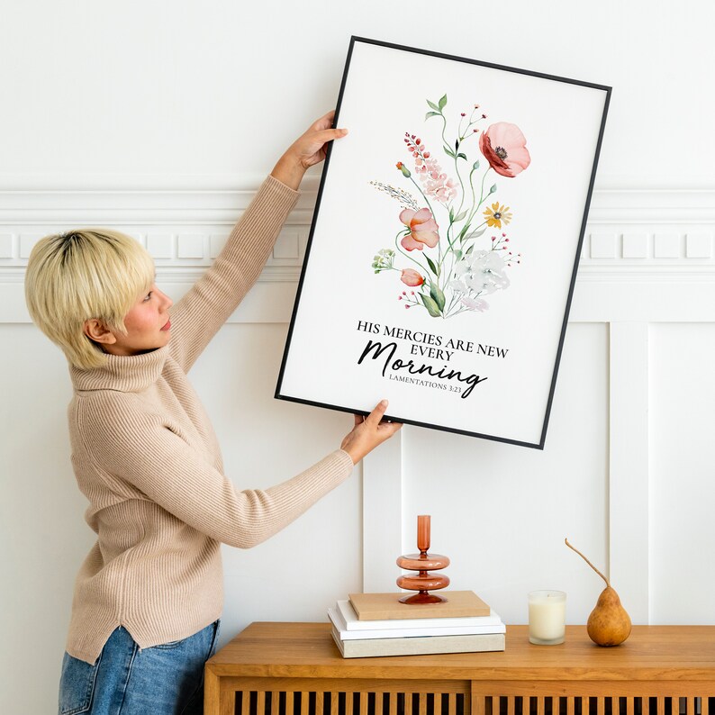 May include: A black framed print with a watercolour floral design and the text "His mercies are new every morning, Lamentations 3:23".