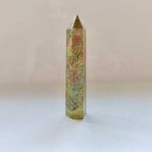 May include: A white ceramic mug with a black handle and the text "But First, Coffee" in a bold, black font. The mug is set against a blurred background, suggesting a cozy setting. The mug appears to be approximately 4 inches tall.