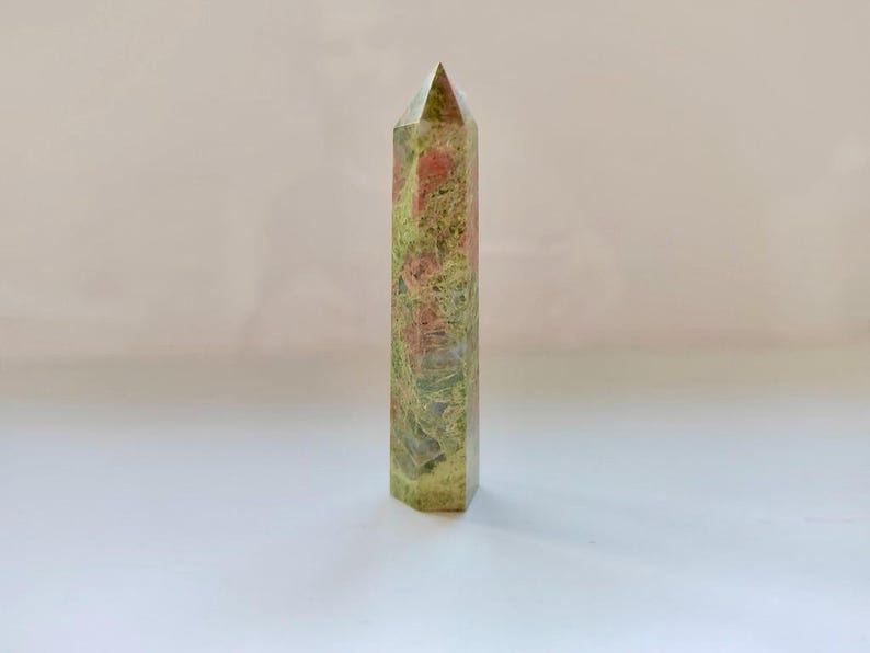 May include: A white ceramic mug with a black handle and the text "But First, Coffee" in a bold, black font. The mug is set against a blurred background, suggesting a cozy setting. The mug appears to be approximately 4 inches tall.