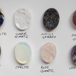 Pu&ograve; includere: Assortimento di 10 pietre ovali levigate, tra cui sodalite, quarzo trasparente, gabbro indaco, quarzo fragola, occhio di tigre, opale, quarzo rosa e lepidolita.