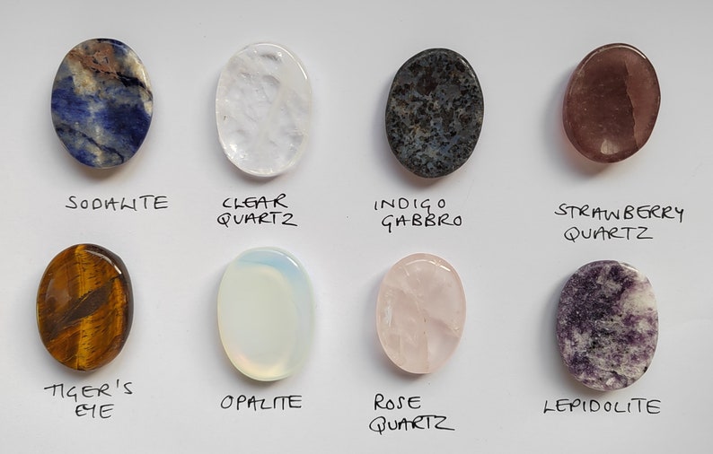 Pu&ograve; includere: Assortimento di 10 pietre ovali levigate, tra cui sodalite, quarzo trasparente, gabbro indaco, quarzo fragola, occhio di tigre, opale, quarzo rosa e lepidolita.