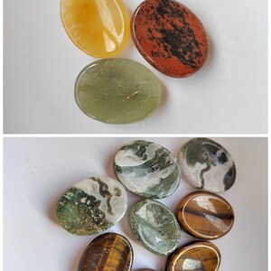 Pu&ograve; includere: Assortimento di pietre ovali levigate in vari colori e motivi, tra cui verde, marrone, bianco e rosso. Le pietre sono lisce e hanno una finitura naturale e lucida.
