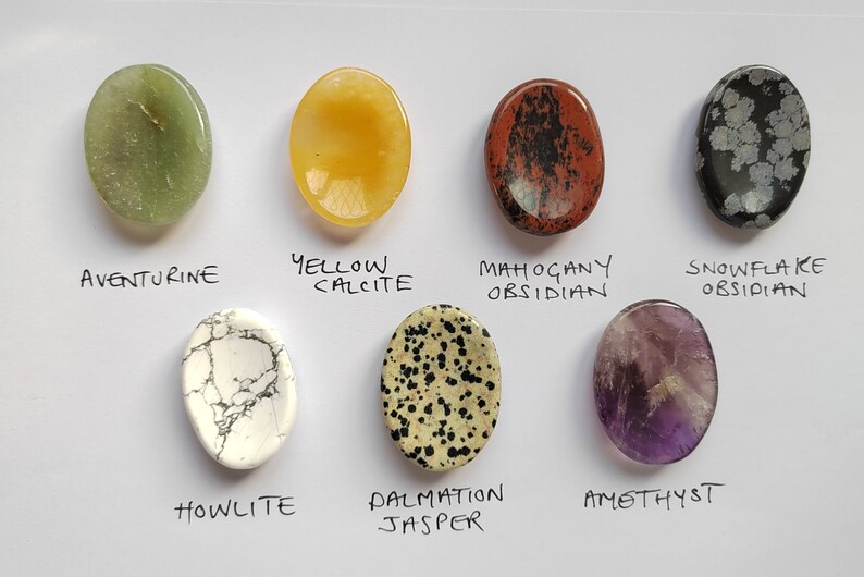 Pu&ograve; includere: Otto pietre ovali lucidate, ciascuna con un colore e un motivo diverso. Le pietre sono etichettate con i loro nomi: Aventurina, Calcite gialla, Ossidiana mogano, Ossidiana fiocco di neve, Howlite, Jaspe dalmata, Ametista.