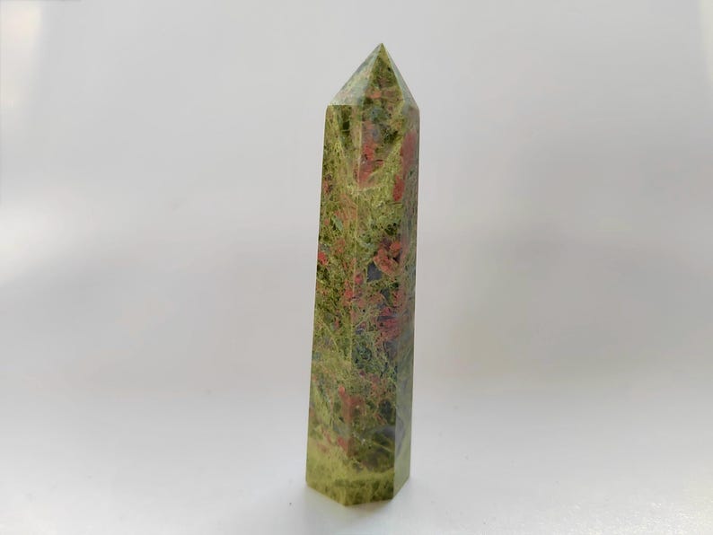 May include: A white ceramic mug with a black handle and the text "But First, Coffee" in a handwritten style. The mug is on a white surface. The mug is likely for hot beverages.