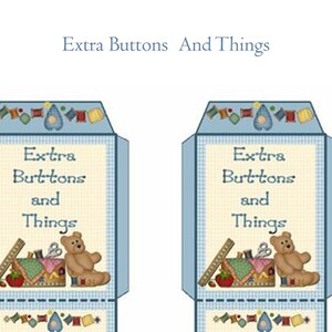 May include: Two blue and white fabric boxes with a light blue background. The boxes have a white and blue checkered pattern and a border of colorful fabric scraps. The boxes have a white label with the text "Extra Buttons and Things" and a cartoon image of a teddy bear holding a sewing needle and thread.