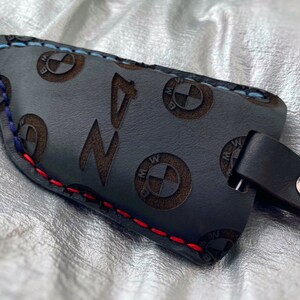 May include: Black leather key fob with red, blue, and white stitching. The fob is embossed with the BMW logo and the word "Z4".