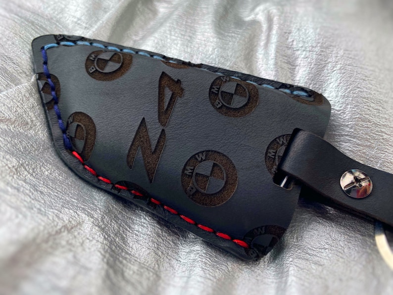 May include: Black leather key fob with red, blue, and white stitching. The fob is embossed with the BMW logo and the word "Z4".