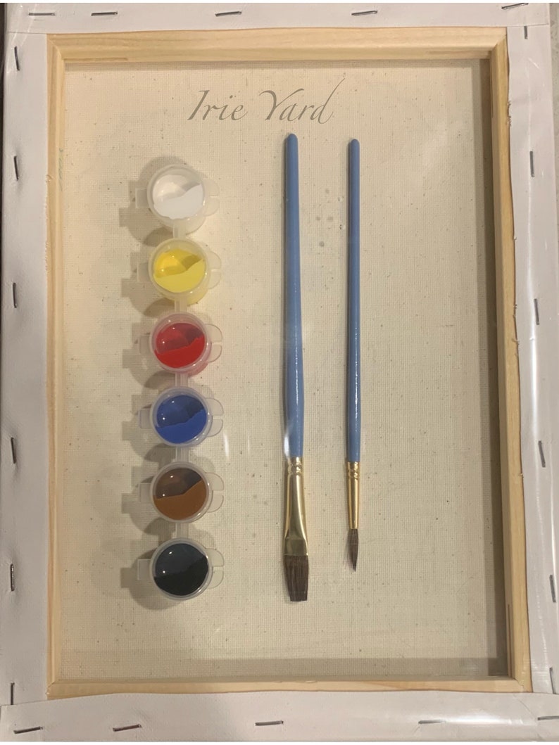 May include: A paint by numbers kit with the title "Irie Yard" on a canvas. The kit includes six small paint pots with white, yellow, red, blue, brown, and black paint. Two paintbrushes are included, one with a flat brush head and one with a round brush head.