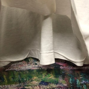 Puede incluir: Una camiseta blanca lisa con un dobladillo cosido.