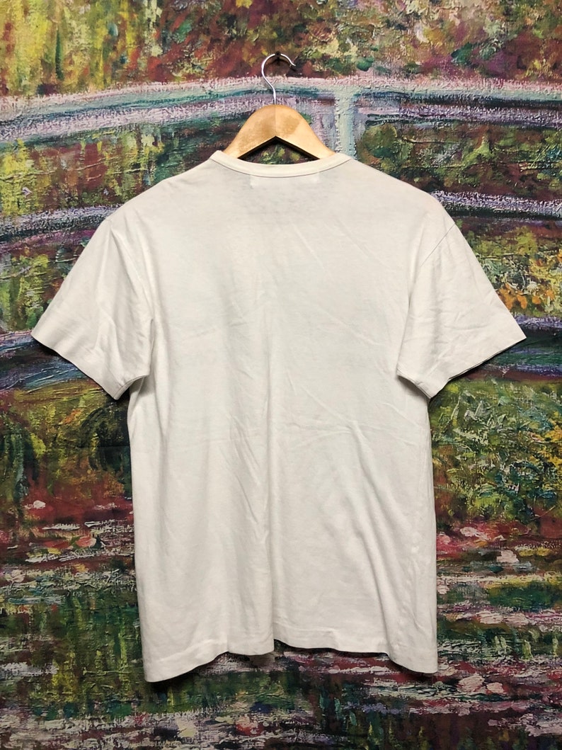 Puede incluir: Una camiseta blanca de manga corta con cuello redondo.