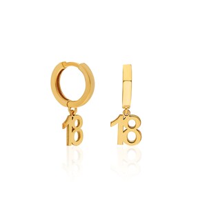 May include: Gold hoop earrings with a dangling charm of the number 18.