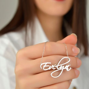 May include: A silver necklace with the name "Evelyn" written in a cursive script.