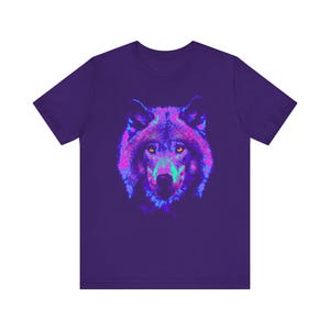 Puede incluir: Una camiseta morada con un gráfico de lobo de color rosa neón, azul y verde en la parte delantera.
