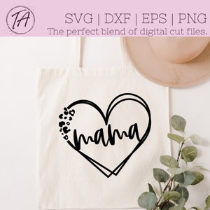 May include: A white tote bag with a black heart design that says "mama" inside. The heart is outlined with a double line and has small black and white spots around it.