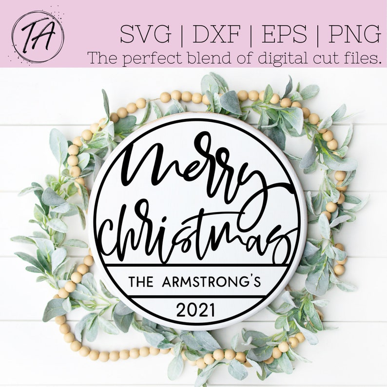 Puede incluir: Un letrero redondo de madera blanco con texto negro que dice "Merry Christmas" con una pancarta negra debajo que dice "The Armstrong's 2021". El letrero est&aacute; rodeado por una guirnalda de hojas verdes y cuentas beige.