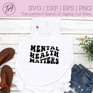 May include: White tank top with black text that reads "MENTAL HEALTH MATTERS" in a retro font with small flower accents.