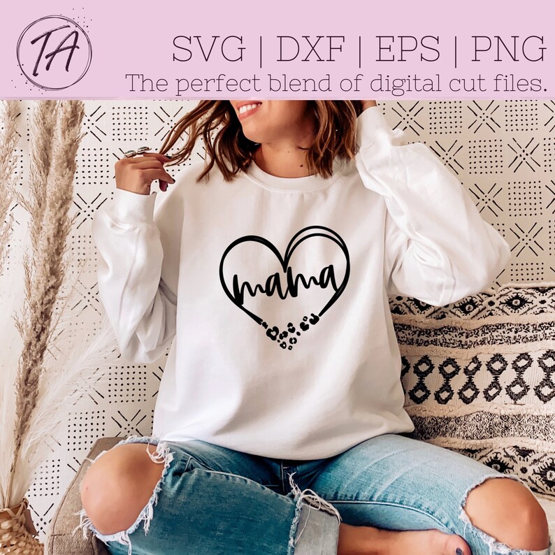 May include: A white sweatshirt with a black heart design that says "mama" inside the heart. The heart is surrounded by small black paw prints.