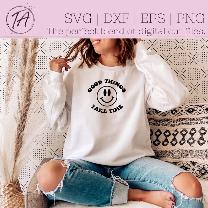 May include: White sweatshirt with black text that reads "Good Things Take Time" and a black smiley face graphic.