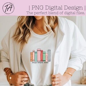 May include: A white t-shirt with a graphic of a stack of colorful books and the text "fully booked, sorry."