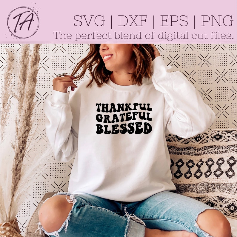 May include: White sweatshirt with black text that reads "Thankful Grateful Blessed" in a retro font.