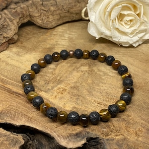 Peut inclure: Un bracelet en perles brunes et noires avec des perles de œil de tigre et de lave.
