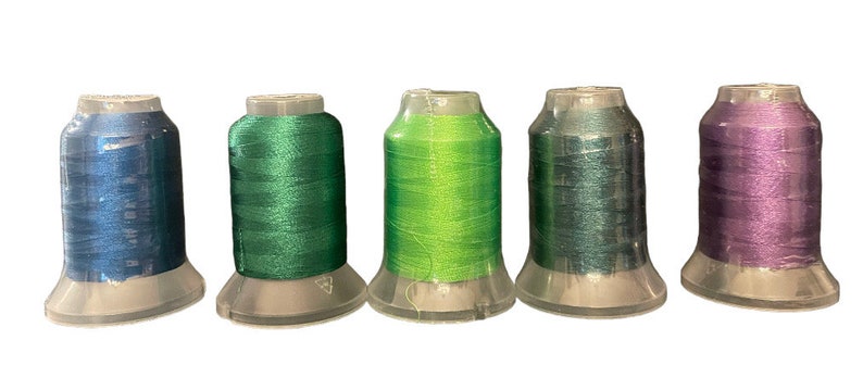 May include: Five spools of thread in different colors: blue, green, lime green, teal, and purple.