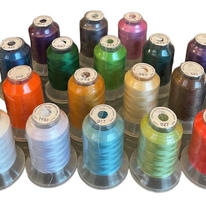 May include: Assortment of 20 spools of thread in various colors, including white, orange, green, blue, and brown. Each spool is labeled with a color number.