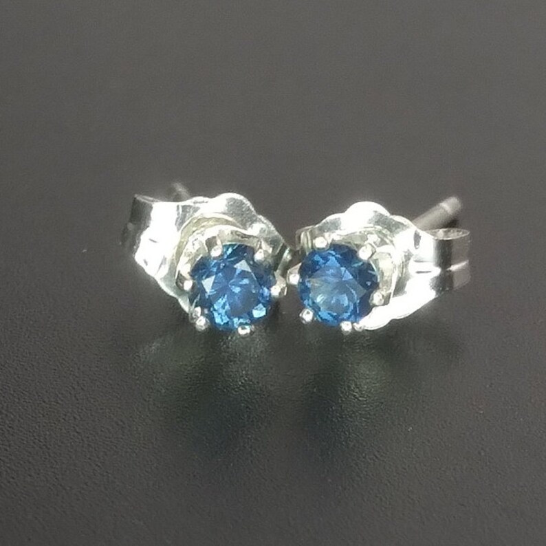 Puede incluir: Un par de pendientes de plata con piedras preciosas azules.