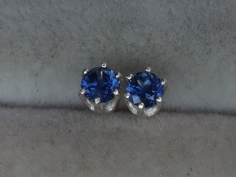 Puede incluir: Un par de pendientes de plata con piedras preciosas azules.