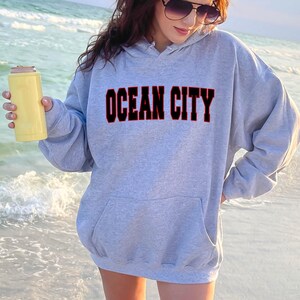 May include: A gray hooded sweatshirt with the text "OCEAN CITY" in red outlined black letters.