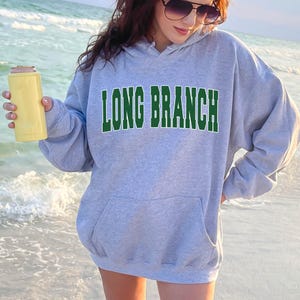 May include: A gray hooded sweatshirt with the text "LONG BRANCH" in green letters.