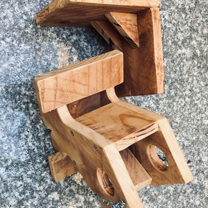 Pu&ograve; includere: Un mangiatoia per uccelli in legno con una catena appesa alla parte inferiore. La mangiatoia ha una piccola apertura sul lato e un posatoio in cima. La mangiatoia &egrave; realizzata in legno naturale e ha un aspetto rustico.