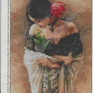 May include: A cross-stitch embroidery pattern featuring a person with dark hair adorned with a red flower, wearing a black off-the-shoulder top and a white shawl. The person holds a yellow rose. Text on the side reads Design/Dessin/Diseño Hadley House Licensing, Lee Bogle 2015.
