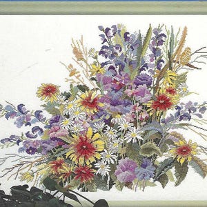 May include: A framed cross-stitch floral arrangement featuring a vibrant bouquet of flowers. The design includes red, yellow, purple, and white blooms, with green foliage. The artwork is set against a white background and framed in a light green border.